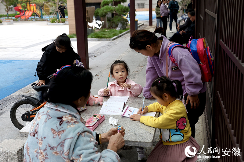 放學(xué)后，孩子們聚在廣場長廊寫作業(yè)。人民網(wǎng)記者 張俊攝
